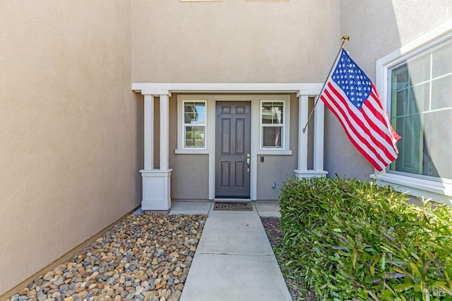 entrance to property featuring stucco siding