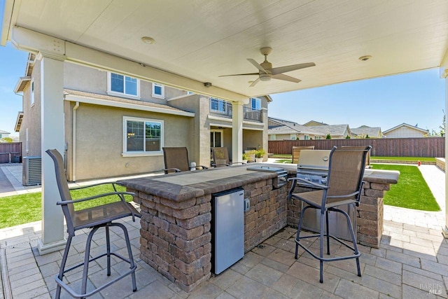view of patio / terrace featuring a fenced backyard, central AC, area for grilling, and outdoor wet bar