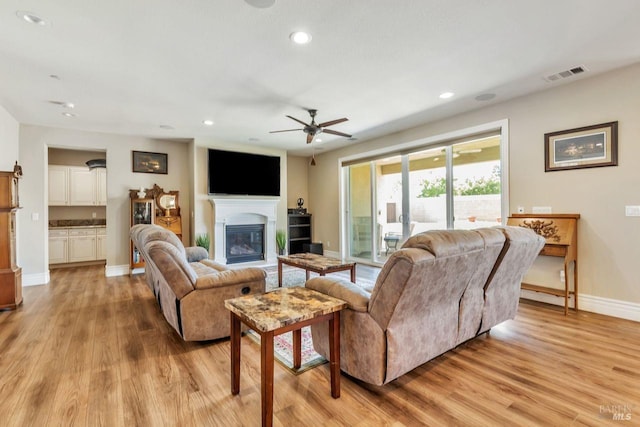 living area featuring baseboards, recessed lighting, light wood-style flooring, visible vents, and ceiling fan