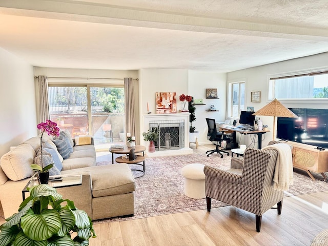 50 Via Belardo Unit 12, Greenbrae, CA 94904 - living room featuring beam ceiling, an office area, wood finished floors, and a fireplace with raised hearth
