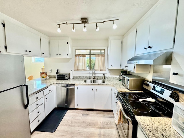 50 Via Belardo Unit 12, Greenbrae, CA 94904 - kitchen featuring appliances with stainless steel finishes, under cabinet range hood, light wood finished floors, white cabinetry, and a textured ceiling