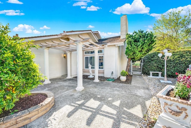 410 Duvall Ct, Benicia, CA 94510 - rear view of property featuring a pergola, stucco siding, fence, a gate, and a chimney