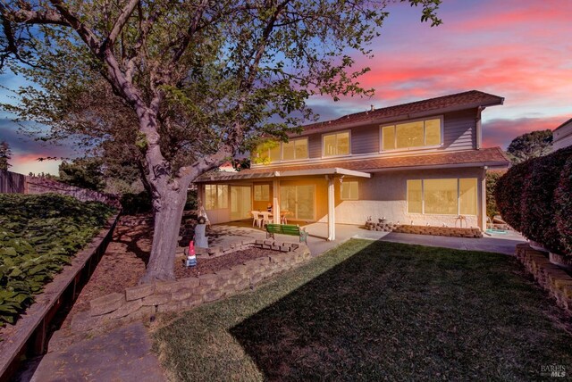 410 Duvall Ct, Benicia, CA 94510 - back of house at dusk featuring a patio, a yard, and stucco siding