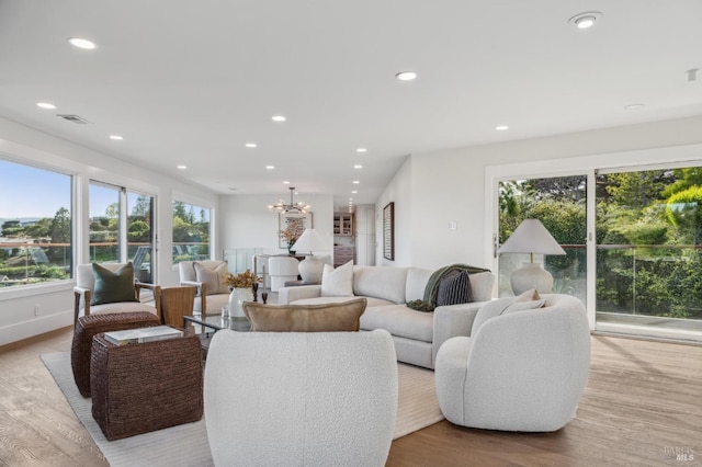 living area featuring an inviting chandelier, recessed lighting, visible vents, and wood finished floors