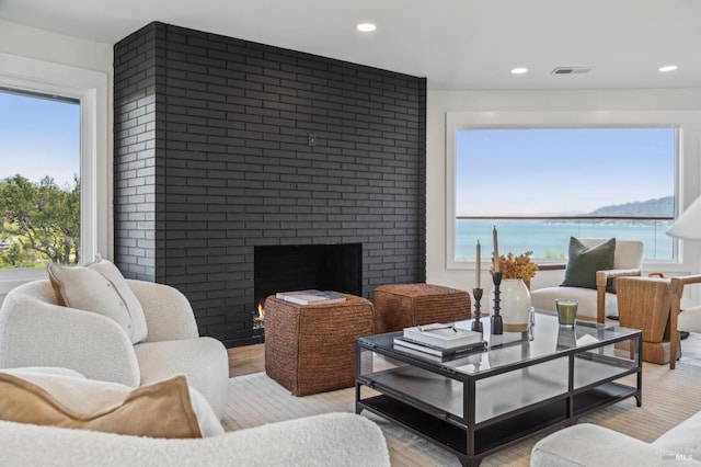 living room featuring a fireplace, a wealth of natural light, light wood-type flooring, and recessed lighting