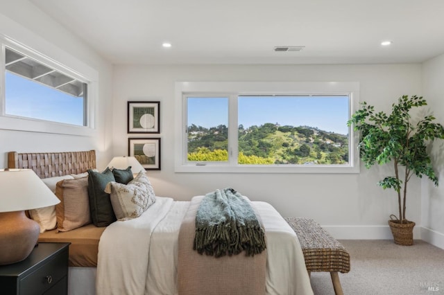 carpeted bedroom with recessed lighting, multiple windows, and visible vents