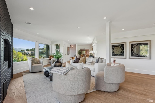 living area featuring a fireplace, baseboards, and wood finished floors