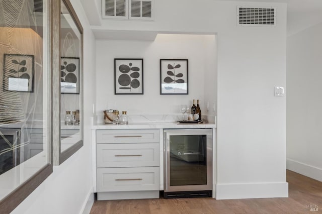 bar featuring visible vents, baseboards, bar area, and wine cooler