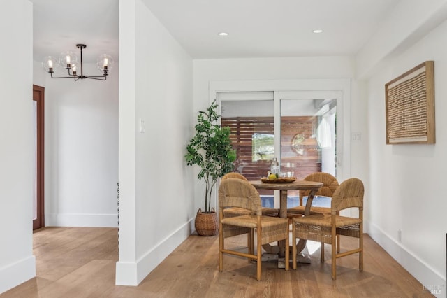 dining space featuring recessed lighting, light wood-style flooring, baseboards, and a notable chandelier