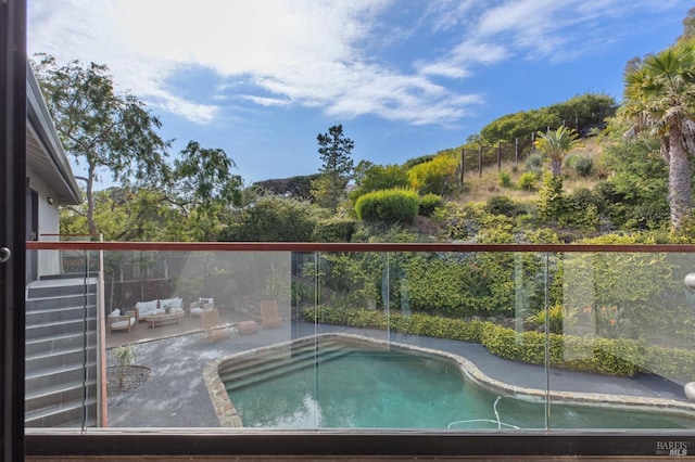view of swimming pool featuring an outdoor hangout area and fence
