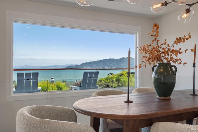 dining room featuring a water and mountain view and a wealth of natural light