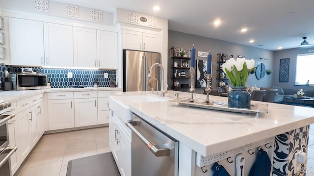 324 Pear Tree Ter Unit D, Napa, CA 94558 - kitchen featuring stainless steel appliances, an island with sink, white cabinets, open floor plan, and backsplash