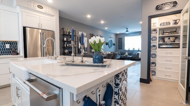 324 Pear Tree Ter Unit D, Napa, CA 94558 - kitchen with appliances with stainless steel finishes, white cabinetry, a center island with sink, light stone countertops, and recessed lighting