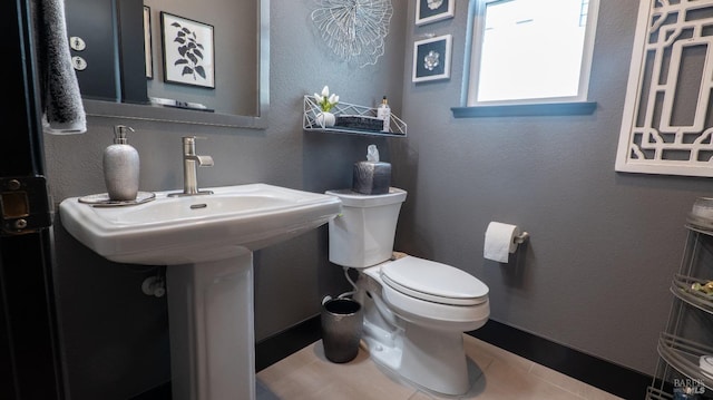 bathroom with baseboards, a sink, and toilet