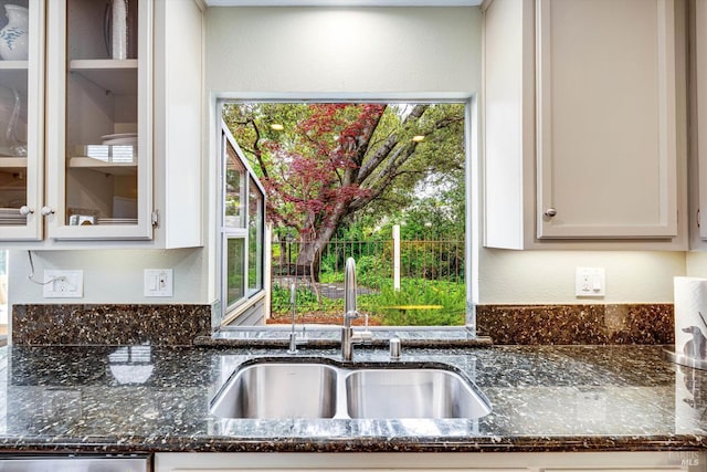 1206 Cayetano Dr, Napa, CA 94559 - kitchen with dark stone countertops, dishwasher, a textured wall, a sink, and glass insert cabinets