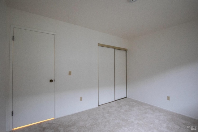 unfurnished bedroom featuring carpet flooring and a closet