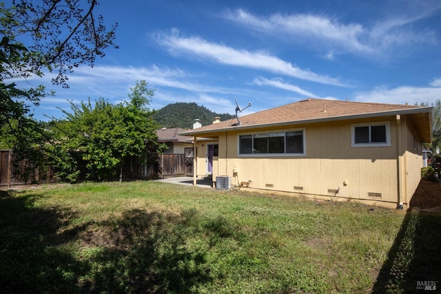 back of house with crawl space, a patio area, central AC, a yard, and fence