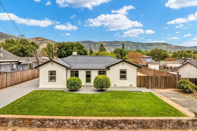 single story home featuring stucco siding, a mountain view, a chimney, and a front yard