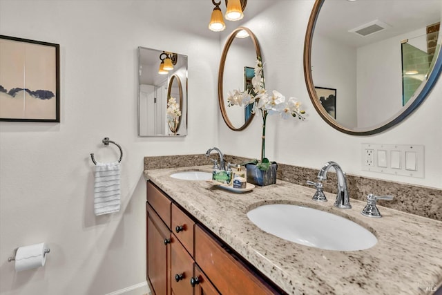 bathroom featuring double vanity, visible vents, baseboards, and a sink