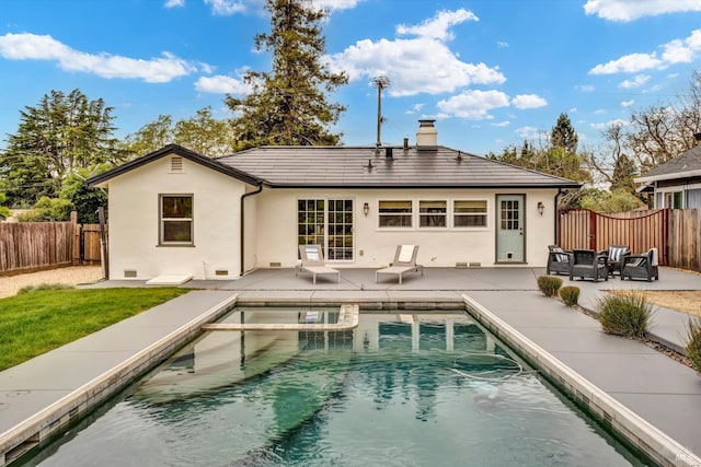 rear view of house featuring a patio area, a fenced backyard, a fenced in pool, and stucco siding
