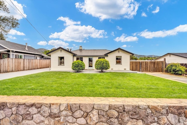view of front facade featuring stucco siding, a front lawn, and fence
