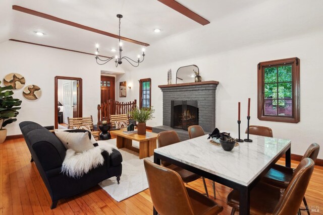 12 Jones Way, Larkspur, CA 94939 - living area with baseboards, a brick fireplace, light wood-type flooring, and an inviting chandelier