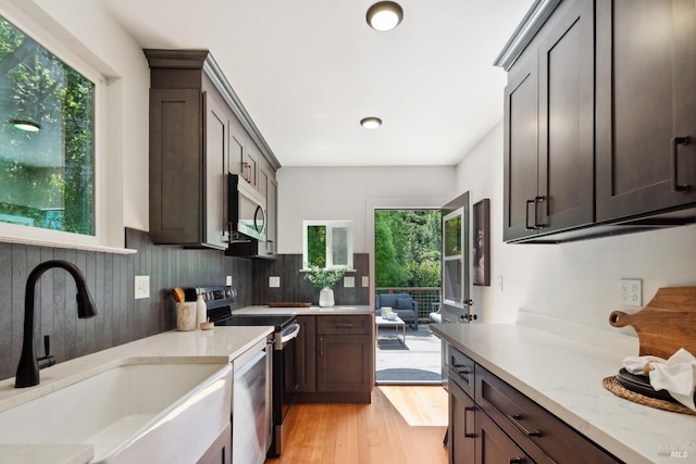 12 Jones Way, Larkspur, CA 94939 - kitchen featuring a sink, appliances with stainless steel finishes, dark brown cabinetry, light stone countertops, and light wood-style flooring