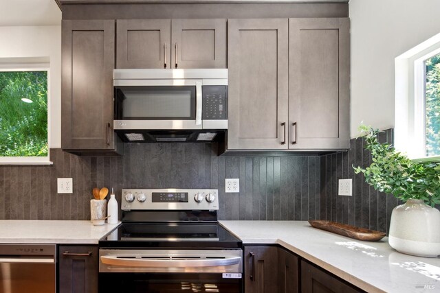 12 Jones Way, Larkspur, CA 94939 - kitchen with backsplash, light countertops, dark brown cabinetry, and stainless steel appliances