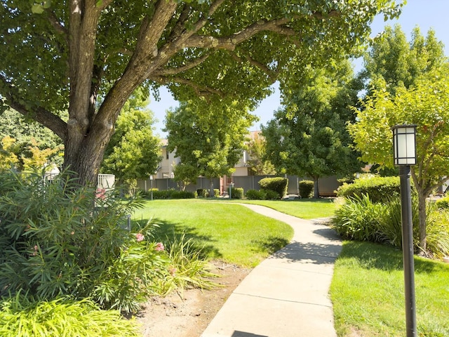 view of community featuring fence and a yard