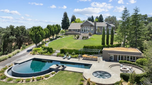 rear view of property with stairway, a fire pit, an in ground hot tub, and a lawn