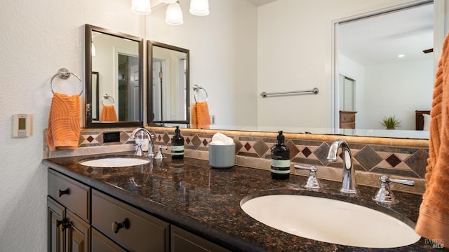 bathroom featuring double vanity, decorative backsplash, and a sink
