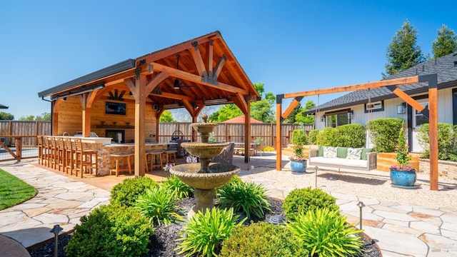 view of patio / terrace with a gazebo, fence private yard, and outdoor dry bar