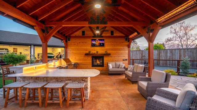 view of patio / terrace featuring fence, a gazebo, area for grilling, outdoor dry bar, and outdoor lounge area