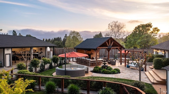 rear view of property with a patio, a shingled roof, an outdoor hangout area, a gazebo, and fence