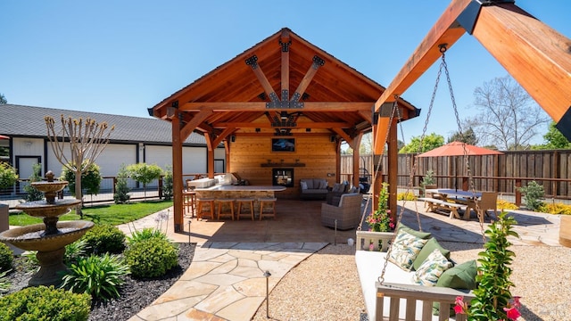 view of patio / terrace featuring an outdoor hangout area, a gazebo, exterior bar, and fence