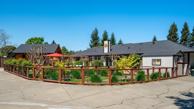 view of front facade featuring a chimney and fence