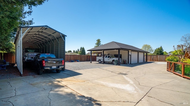 view of vehicle parking with fence, concrete driveway, and a garage