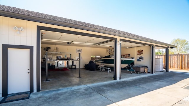 view of parking with a garage and fence