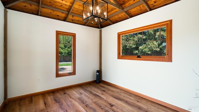spare room with wood ceiling, baseboards, wood finished floors, a notable chandelier, and vaulted ceiling with beams
