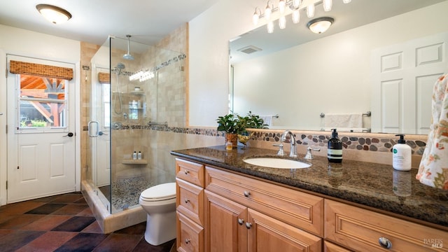 bathroom featuring visible vents, a shower stall, toilet, and vanity