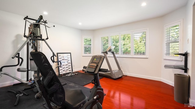 exercise room with recessed lighting, baseboards, wood finished floors, and plenty of natural light