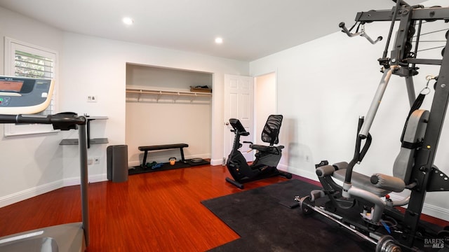 exercise area with wood finished floors, recessed lighting, and baseboards