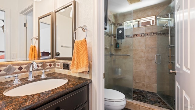 bathroom with vanity, toilet, and a shower stall