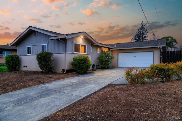 ranch-style home with a garage, driveway, and fence