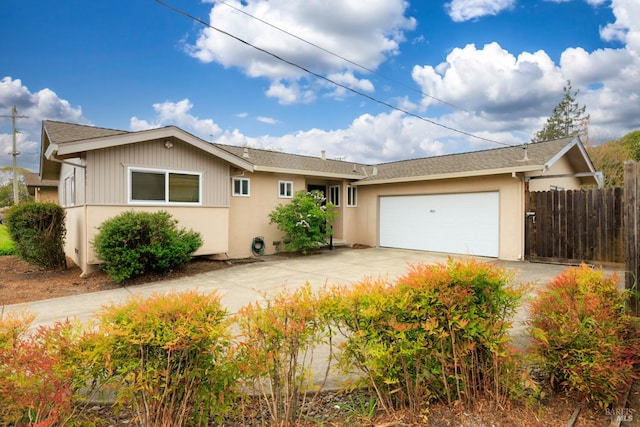 ranch-style home featuring concrete driveway, roof with shingles, stucco siding, a garage, and fence