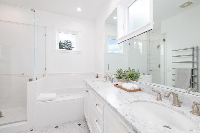bathroom featuring a shower stall, a garden tub, a sink, and visible vents