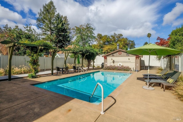 view of pool featuring a patio, a fenced backyard, a fenced in pool, and an outdoor structure