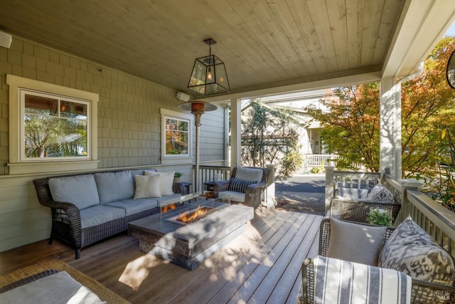 wooden terrace with an outdoor living space with a fire pit