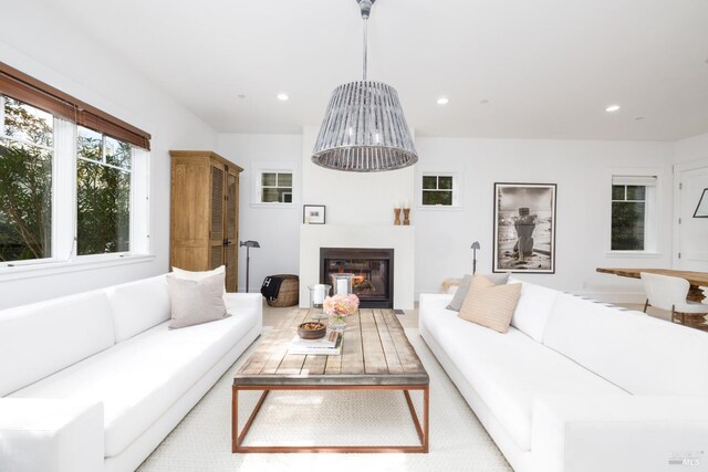 living room with a glass covered fireplace and recessed lighting