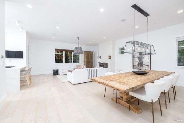 dining room with recessed lighting, light wood-style flooring, and baseboards